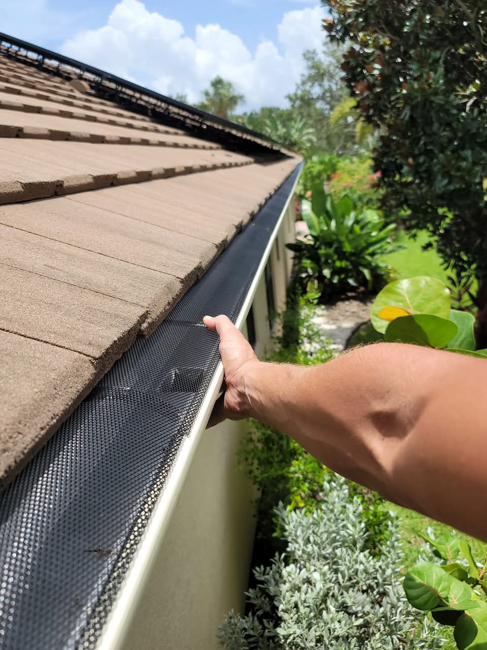 Eli inspecting an installed leaf guard on a seamless gutter — professional gutter protection