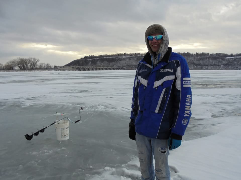 Eli Buss ice fishing on a frozen river in Wisconsin — Yamaha jacket, before moving to East Tennessee